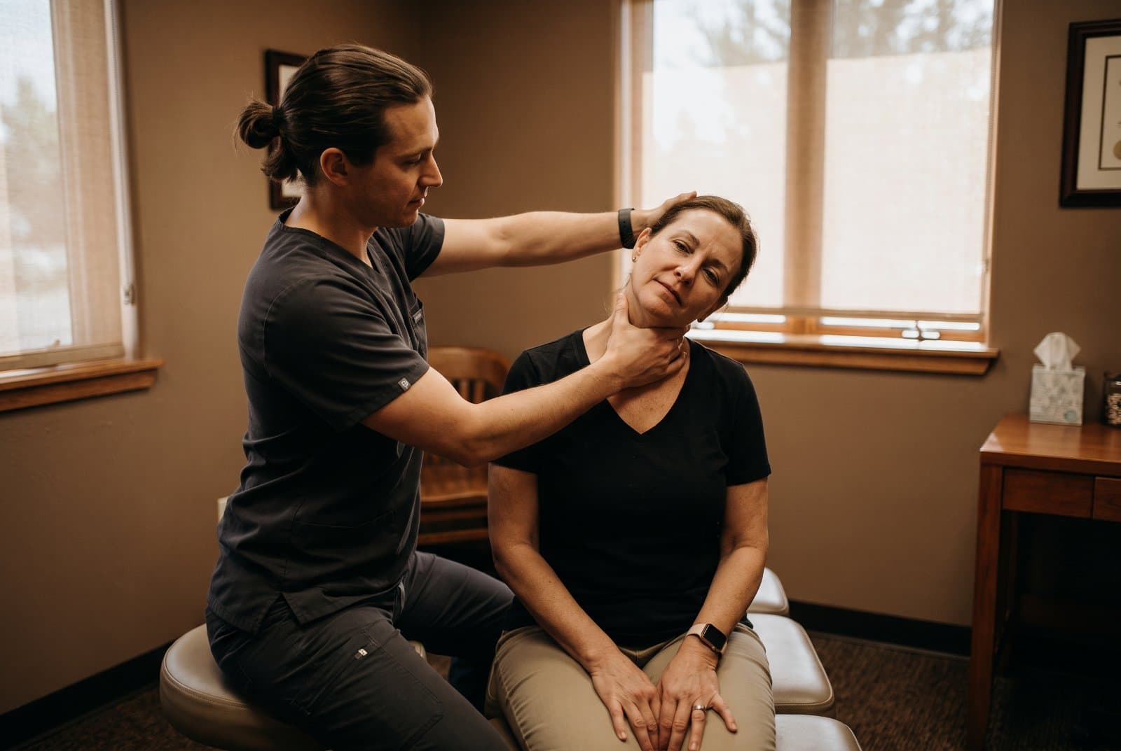 Doctor gently assessing a patient's neck range of motion